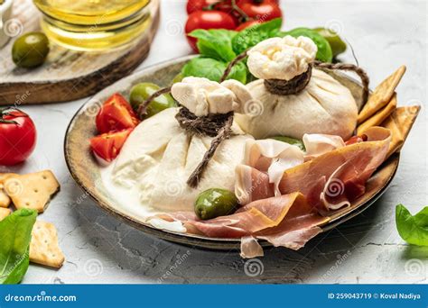 tagliere di legno con burrata affumicata e ingredienti