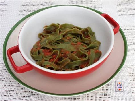Un piatto di tagliatelle verdi al pomodoro servite