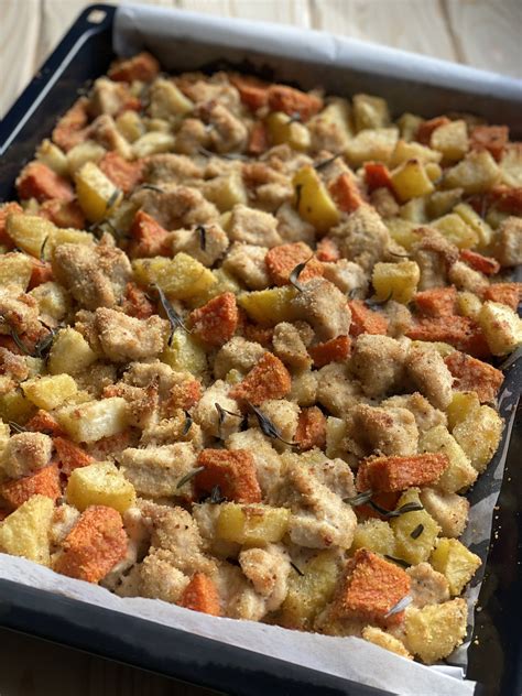 Teglia con pollo, zucca e erbe aromatiche pronta per andare in forno