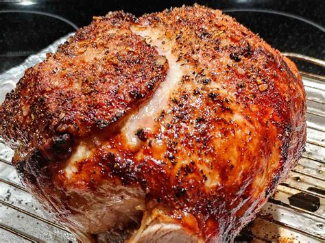 A butcher hand-massaging salt onto a pork leg