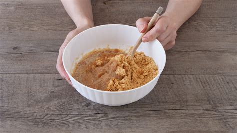 Biscotti tritati mescolati con burro fuso in una ciotola