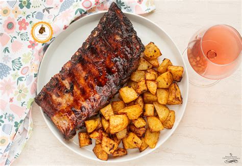 Costine di maiale e patate pronte per essere cotte nella friggitrice ad aria