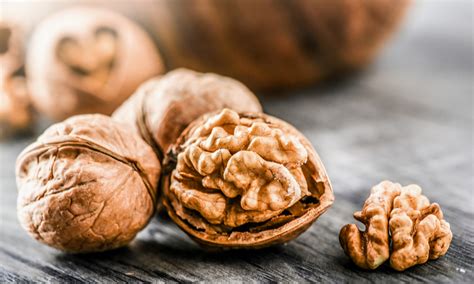 noci intere e tritate sparse su una superficie di legno