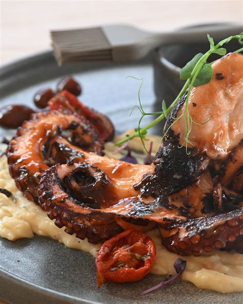 Un polpo fresco adagiato su un tagliere di legno