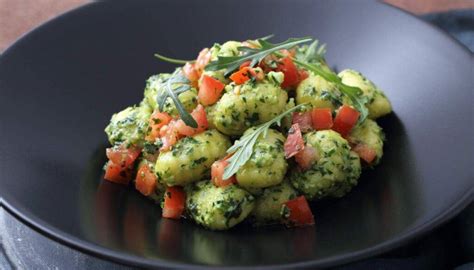 Piatto di gnocchi al pesto con pomodorini