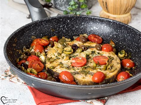 Pesce spada fresco con pomodorini e olive in una padella