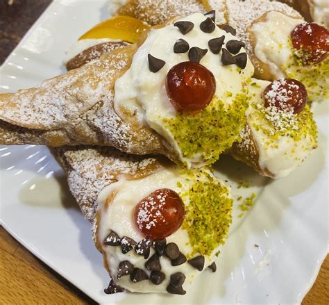 Primo piano di un cannolo senza glutine con ripieno di ricotta e gocce di cioccolato