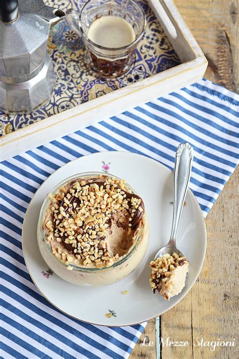 Immagine di una mousse di ricotta e caffè in una coppa di vetro decorata con scaglie di cioccolato