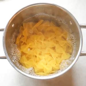 Una pentola di farfalle che cuoce in acqua bollente salata