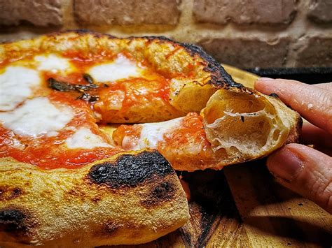 Pizza appena sfornata con cornicione alto e dorato