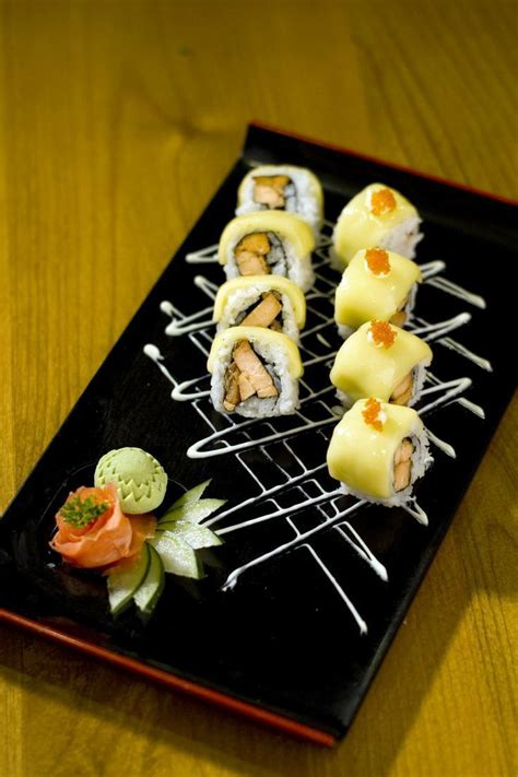 Piatto di sushi misto artisticamente presentato con guarnizioni fresche