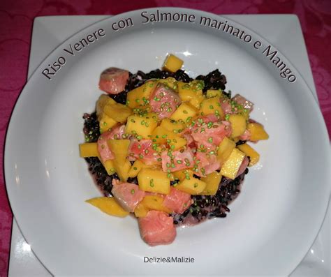 Composizione di riso venere, salmone, mango e verdure colorate