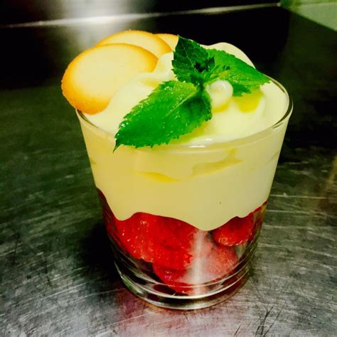 Una coppa di zabaione freddo con fragole e foglioline di menta