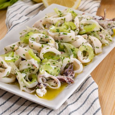 Componenti di un'insalata di Brie, uva e sedano disposti su un piano di lavoro
