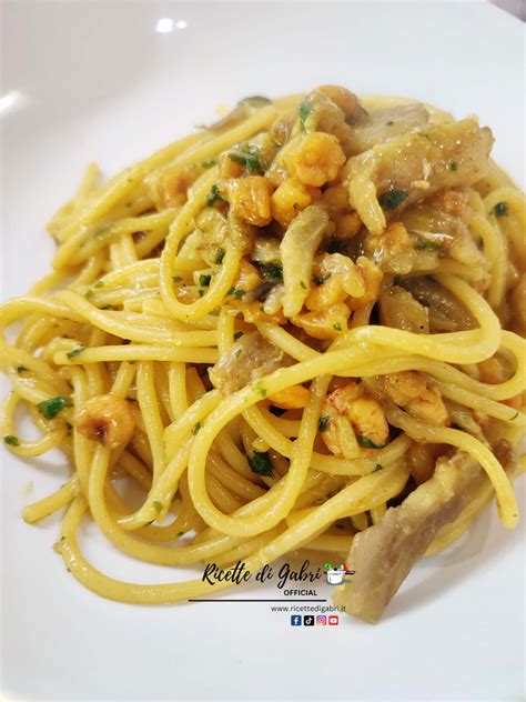 Immagine di un piatto di pasta con gamberi e carciofi, con speck croccante a guarnire