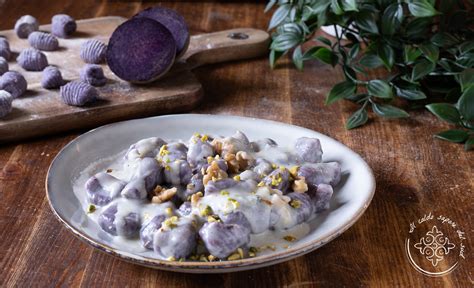 Gnocchi di patate viola serviti con salsa ai porri e limone