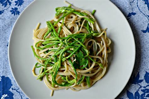 Un piatto di spaghetti alla carbonara con asparagi selvatici.