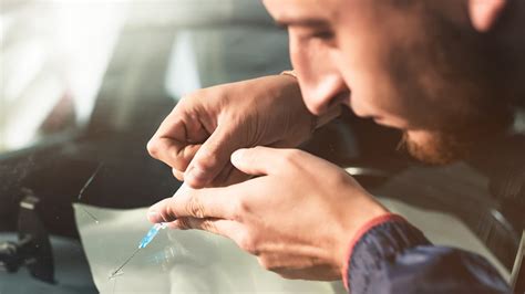 Tecnico che ripara un parabrezza scheggiato con resina