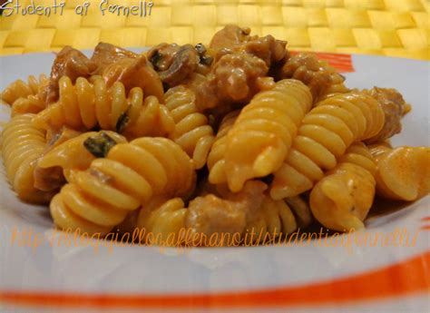 Un piatto di fusilli con salsiccia e funghi, guarnito con prezzemolo fresco