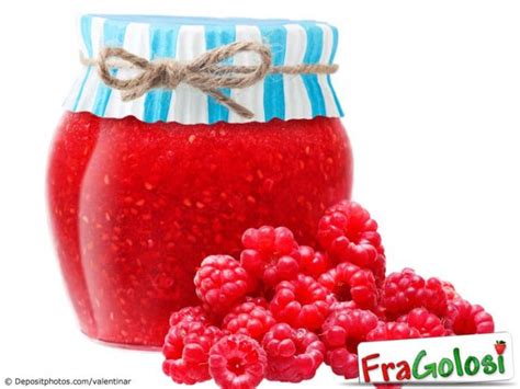 Un barattolo di confettura di lamponi accanto a una ciotola
