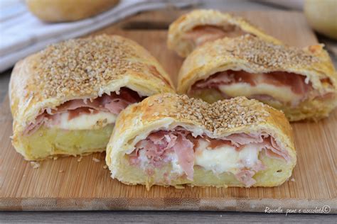 Un rotolo di pasta sfoglia aperto che mostra il ripieno di tacchino e formaggio