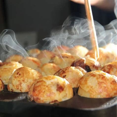 Preparazione dei takoyaki su una piastra apposita