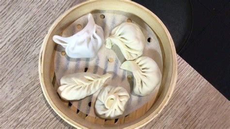 Dettaglio delle mani che chiudono un raviolo cinese