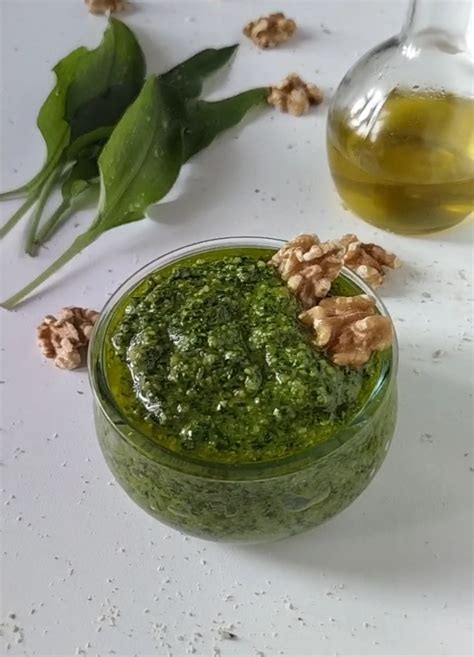 Ingredienti per il pesto di aglio orsino disposti su un tagliere di legno