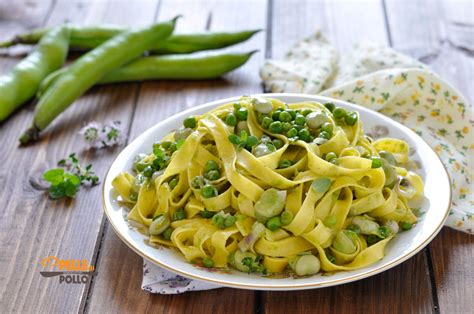 Una padella con pasta, fave e piselli che vengono mantecati