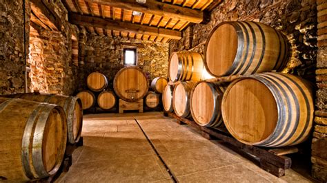 Cantina con botti di legno e uve in appassimento