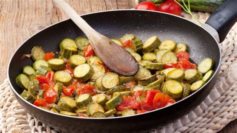 Zucchine fresche con pomodorini e olive in una padella
