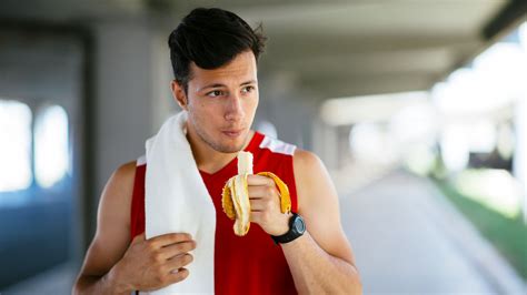 Atleta che mangia una banana durante una pausa sportiva