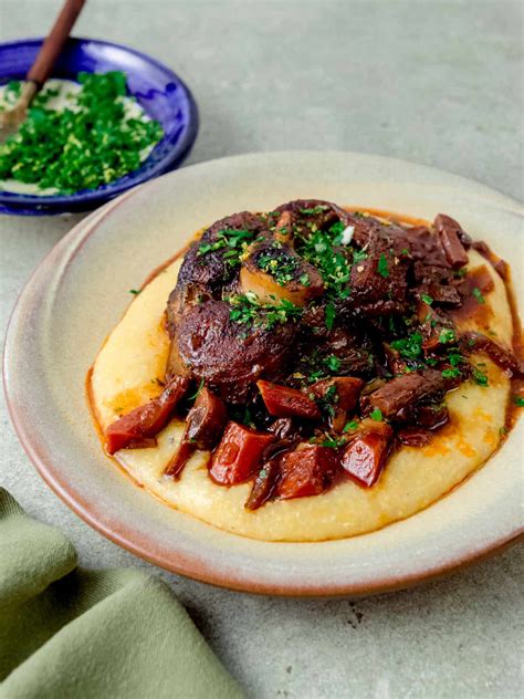 Piatto finito di Osso Buco di Maiale con polenta e gremolata