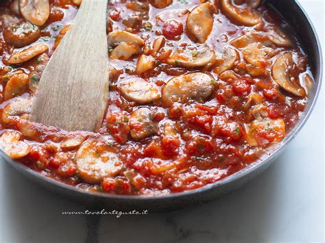 Pezzi di pollo e funghi in un tegame con sugo