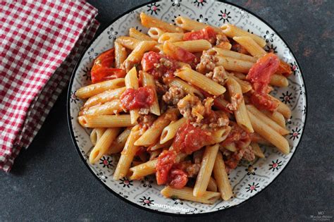 Immagine di una padella fumante con pasta, salsiccia e pomodorini