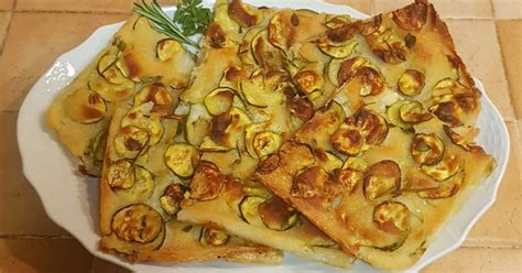 Tagliere con schiacciata di zucchine a cubetti e formaggi