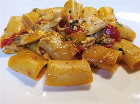 Piatto finito di paccheri con ricciola e pomodorini