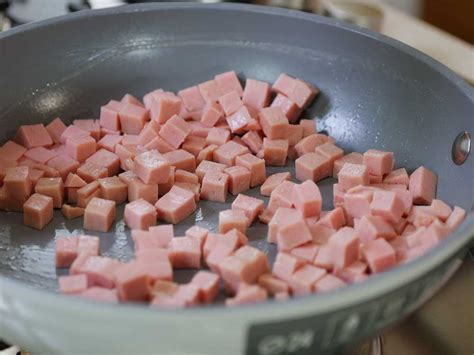 Padella con cubetti di prosciutto cotto che caramellano in aceto balsamico e miele