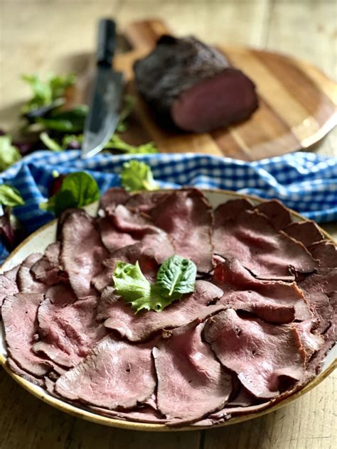 Un piatto di roast beef affettato con contorno