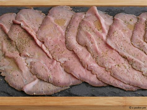 Un piatto di roast beef affettato finemente con una salsa