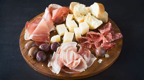 Diverse tipologie di salumi e formaggi tagliati a cubetti, pronti per essere aggiunti all'impasto del migliaccio.