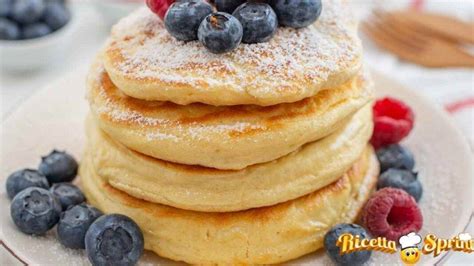 Una pila di soffici pancake senza uova guarniti con frutta fresca e sciroppo d'acero