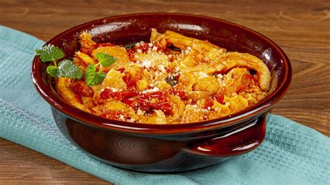 Ingredienti freschi per la trippa alla romana disposti su un tavolo di legno