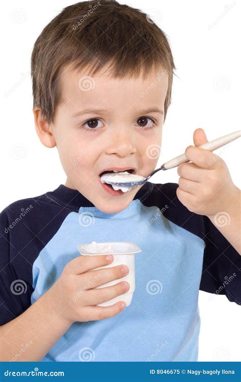 Bambino che mangia uno yogurt con un cucchiaino