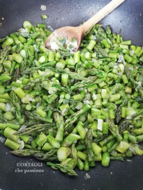 Punte di asparagi che vengono cotte in padella