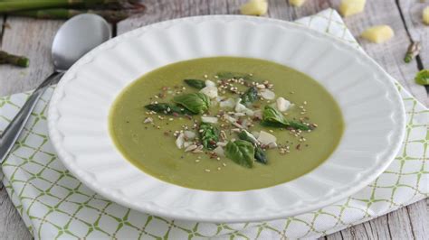 Composizione di piatti con crema di asparagi e spinaci, sorbetto al limone e macedonia di frutta