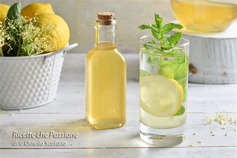 Un assortimento di ingredienti per cocktail: gin, limoni, menta, sciroppo di sambuco