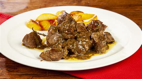 Ingredienti per l'abbacchio alla cacciatora disposti su un tagliere