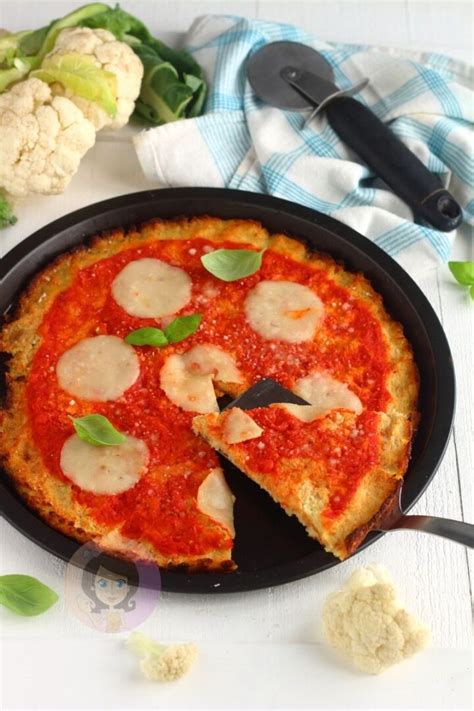 Pizza con base di cavolfiore condita e pronta per essere infornata