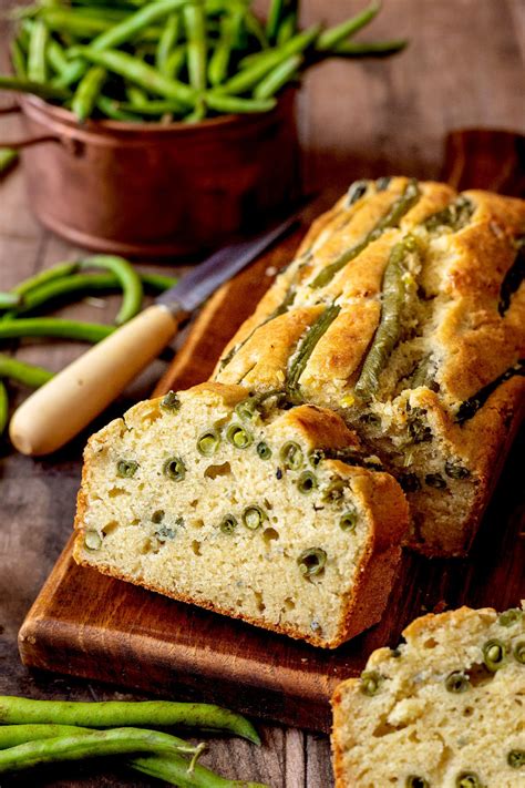 Immagine di un plumcake salato tagliato a fette, mostrando i fagiolini, le noci e il formaggio all'interno.
